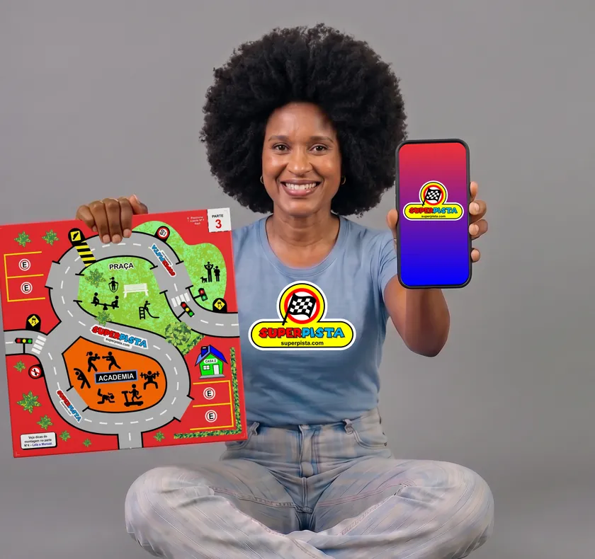 Mulher sentada no chão, sorrindo, com uma peça do tabuleiro Super Pista numa mão e o celular com o logo do aplicativo na outra.